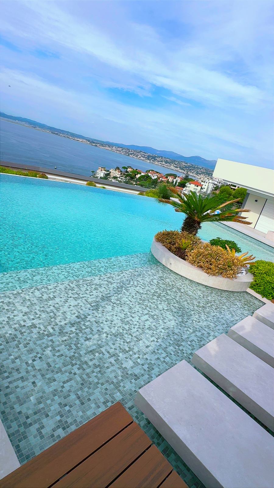 Piscine à débordement en mosaïque avec vue sur la mer
